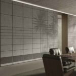 Modern grey grid wallpaper with geometric panel lines and subtle palm leaf shadows in a luxury contemporary interior