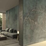 Moody green botanical wallpaper with delicate branches and subtle foliage creating a sophisticated feature wall in a modern living room