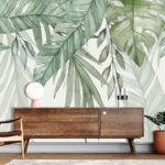 Tropical leaf wallpaper featuring oversized green banana, monstera and palm foliage on a soft neutral background